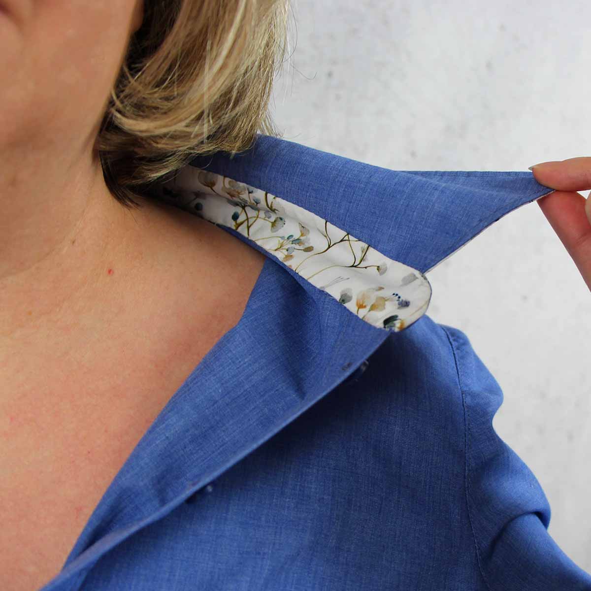Kragen einer Hemdbluse mit dekorativem Kontraststoff auf der Innenseite